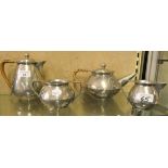 An Art Deco Homeland pewter four piece hammered tea service comprising teapot, hot water pot,