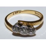 An 18ct gold three stone diamond ring, claw set with graduated illusion set brilliant cut stones,