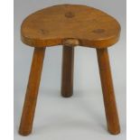 A Peter "Rabbitman" Heap of Wetwang oak three legged stool, shaped dished seat carved with Rabbit