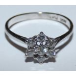 An 18ct white gold diamond cluster ring, claw set with a brilliant cut stone, bordered by six