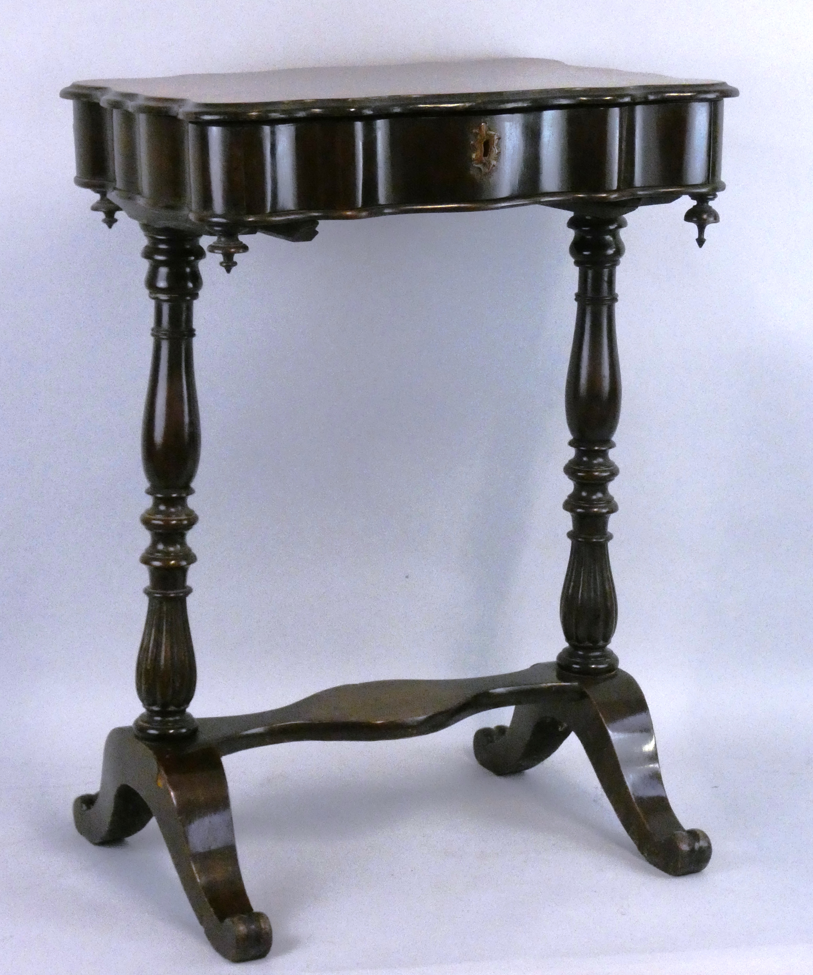 A Victorian mahogany work table, the shaped top opening to reveal a fitted interior with lidded