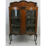 An Edwardian mahogany display cabinet, the bowed stylised leaded glass doors, with boxwood inlaid
