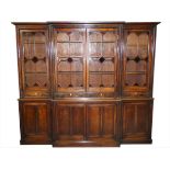A Georgian mahogany breakfront library bookcase, the stepped cornice above a pair of thirteen clear,