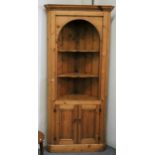 A pine corner cupboard with two shelves