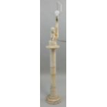 A white alabaster lamp depicting a child by a pillar, raised on a column with a stepped foot,