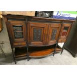 An early twentieth century bow fronted sideboard, central carved panels flanked by two bevel edged