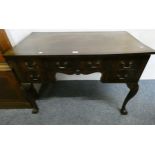 A mahogany kneehole desk with central drawer and two small drawers to each side on curved taping