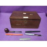 A selection of desktop items including tobacco pipe, pen knife and an erotic pen