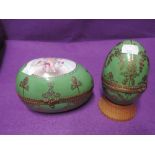 Two porcelain eggs bearing the Sevres mark both hand decorated with green and gilt glaze