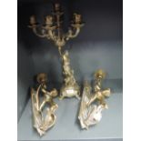 A pair of wall mounted figural cherub lights in brass and similar table centre and candle holder