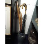 A selection of walking sticks and umbrella within large salt glazed vase