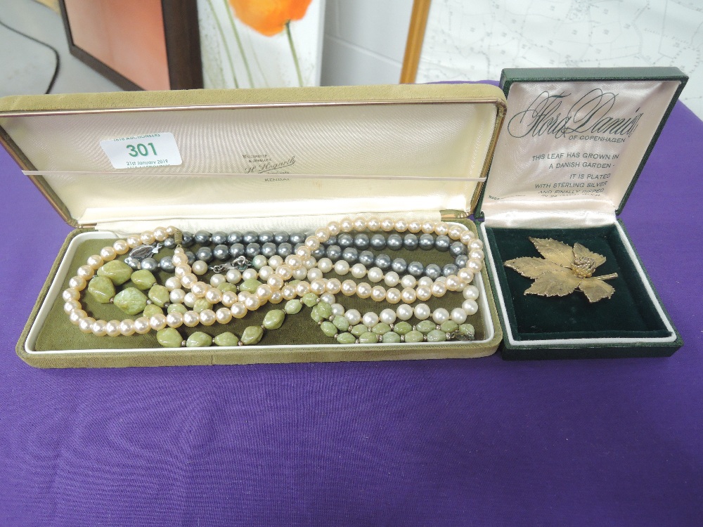 A small selection of costume jewellery including simulated pearls, leaf brooch etc