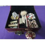 A small jewellery box containing a selection of costume jewellery including beads, brooches,