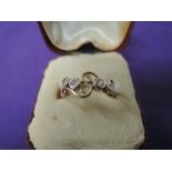 A lady's dress ring having four cubic zirconia in collared mounts within an open curled setting on a
