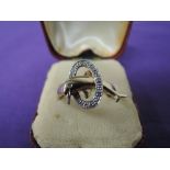 A lady's dress ring having a moulded dolphin diving through a diamond chip decorated hoop on a 9ct
