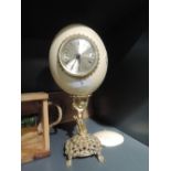An Ostrich egg mantle clock with brass style cherub design bass