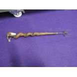 A toasting fork or skewer with natural twist wood handle and four pronged end