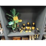 A hand carved and decorated banana plant and crow set