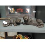 Two otter figures or figurines in playful poses