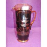 A glass jug or pitcher with ruby glass and cut deer and forest design