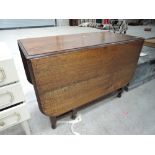 A mid 20th Century oak drop leaf dinner table with twist legs