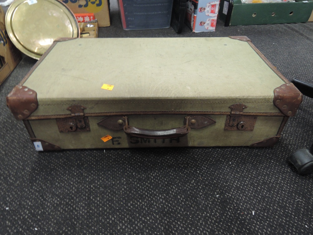 A suitcase with leather and canvas body marked E Smith
