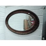 An oval wall mirror