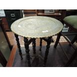 A vintage Anglo Indian style folding brass top table