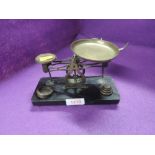 A set of jewellery or chemist balance scales with graduated weight set