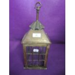 An arts and crafts style porch or similar outside light with brass body and cast glass