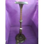 A turned smokers or similar stand with brass cast lions foot base