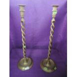 A pair of tall standing barley twist stem candle sticks