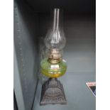 An oil burning lamp or light with heavy cast base and glass well