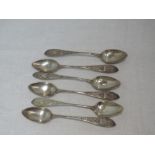 A set of six white metal teaspoons having moulded decoration and plain cartouche to terminals,
