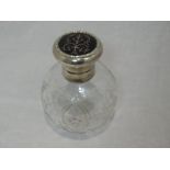 A glass perfume bottle of spherical form having cut floral decoration and silver pique work to