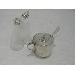 A glass salt and pepper fixed duo having silver collars and lids, Birmingham 1920, Cornelius