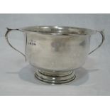 A silver sugar bowl of plain circular form having rub over rim and thumb piece handles, Birmingham