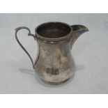 A small Edwardian silver cream jug of baluster form on circular column foot, Sheffield 1908,