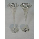 A pair of bud vases having fluted rims and twist stems to circular bases, (one weight missing),