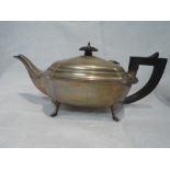 A silver teapot of plain canted oblong form having hard wood handle and finial, quadrafoil paw