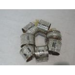 A set of six silver napkin rings having engraved decoration and monogrammed H to cartouches,