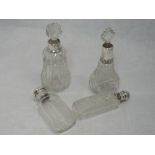 Four cut glass perfume bottles having HM silver collars/lids or glass stoppers