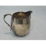 A small silver cream jug of plain form having loop handle, London 1948, maker CE