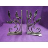 A pair of metal book ends with wrought floral design