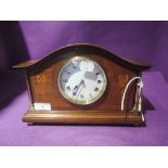A mantle clock with veneer inlay frontage enamel face and brass column supports