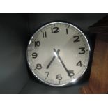 A large faced wall clock with chrome case