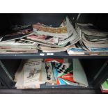 Two shelves of 1950's and later motoring magazines, programmes and similar ephemera including The