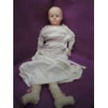 A vintage wax headed doll having fixed eyes and closed mouth, composition limbs and cloth body