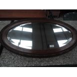 An oak frame oval wall mirror