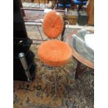 A vintage wirework stool/chair with orange upholstery